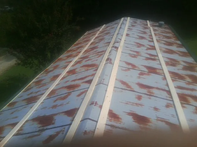 Rusted metal roof panels with new wood purlins before replacement — Storm Damage Roof Repair in Lenore by Roofing Brothers